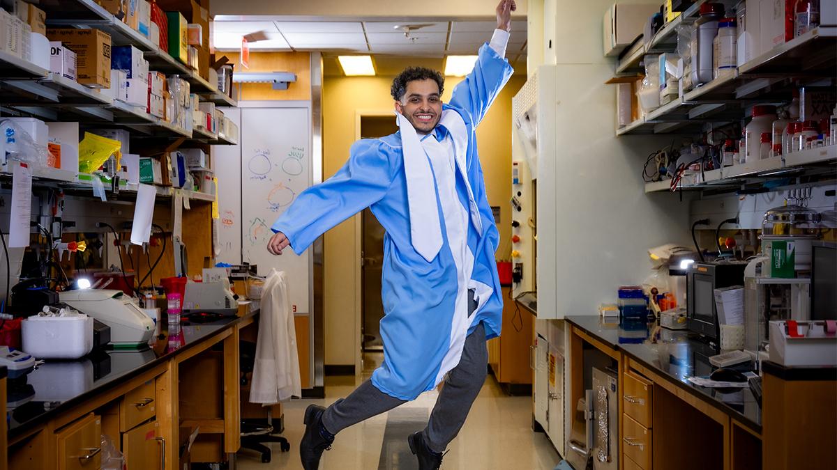 Rami Darawsheh穿着毕业典礼长袍在实验室里跳来跳去.